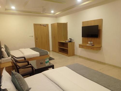 a hotel room with two beds and a flat screen tv at Sun Stone Hotel & Club - Jawai in Sheoganj