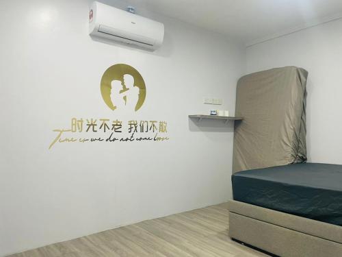 um quarto com uma cama e uma placa na parede em 吉胆168民宿 168PulauKetam GuestHouse em Bagan Teochew