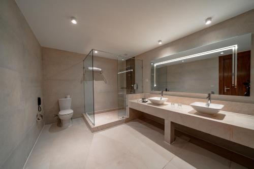 a bathroom with two sinks and a shower and a toilet at Pickalbatros Vita Resort - Portofino Marsa Alam in Abu Dabab