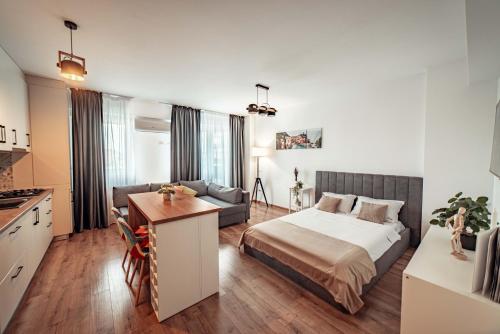 a bedroom with a bed and a couch and a table at Luxury Collection Studios at Q Residence Palas Mall in Iaşi
