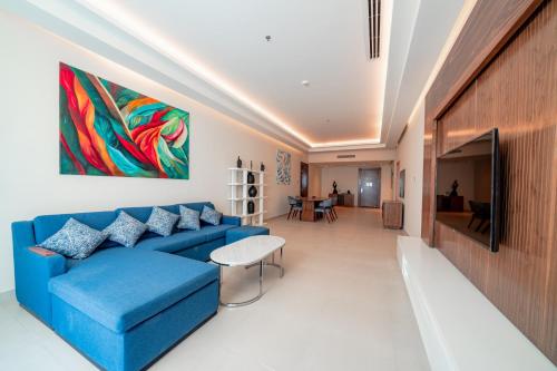 a living room with a blue couch and a painting on the wall at Pickalbatros Vita Resort - Portofino Marsa Alam in Abu Dabab