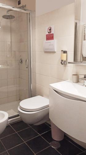 a bathroom with a toilet and a shower and a sink at Roma Resort Termini in Rome