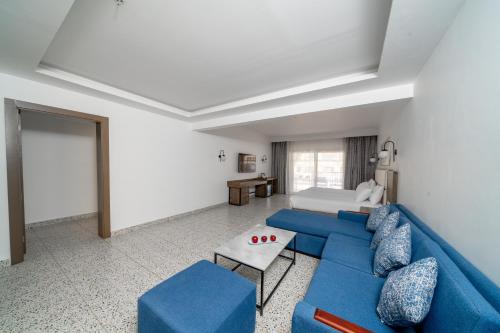 a living room with a blue couch and a table at Pickalbatros Vita Resort - Portofino Marsa Alam in Abu Dabab