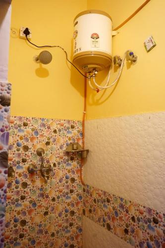 a bathroom with a shower with a bucket on the wall at Malti Home stay 5 minute walking distance fromAyodhya DhamRailway Station in Ayodhya