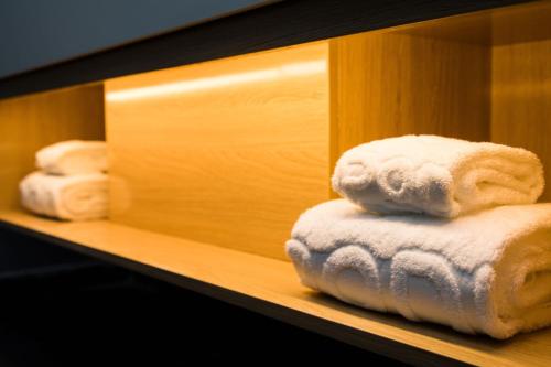 un mucchio di asciugamani seduti su uno scaffale di Chengdu PODI Hotel a Chengdu