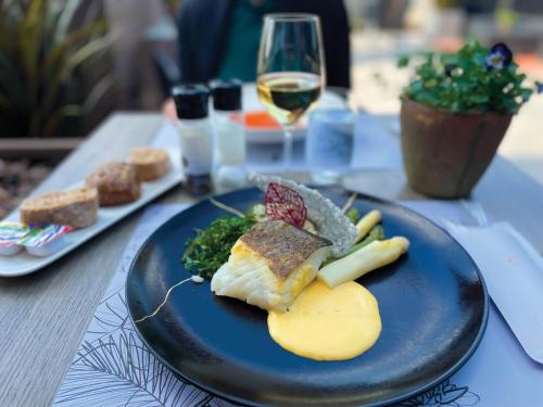 a plate of food on a table with a glass of wine at Hotel Verviers Van der Valk in Verviers