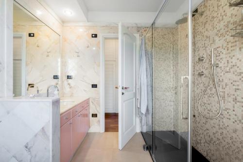 y baño con ducha y lavamanos. en Villa Le Fontanelle In Forte Dei Marmi With Ac en Forte dei Marmi