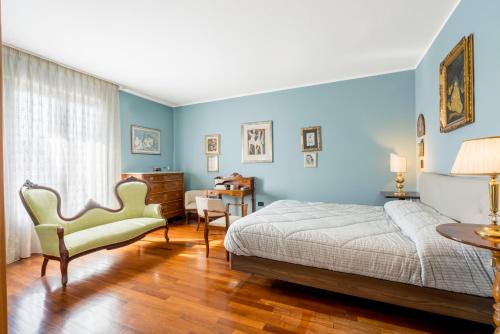 1 dormitorio con paredes azules, 1 cama y 1 silla en Villa Le Fontanelle In Forte Dei Marmi With Ac en Forte dei Marmi
