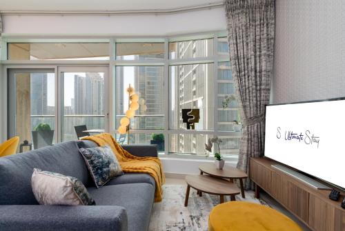 a living room with a couch and a flat screen tv at Ultimate Stay / 2 Beds / Opera and Fountain views in Dubai