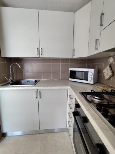 a kitchen with white cabinets and a sink at Casa PIANO TERRA lago di lesina in Lesina