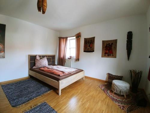 1 dormitorio con cama y ventana en Weltenhaus en Unterumbach