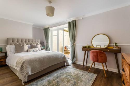 a bedroom with a bed and a mirror and a desk at Stylish 2Bed 2Bath Seafront Patio Apartment in Brighton & Hove