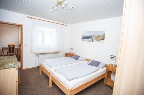 ein Schlafzimmer mit einem großen Bett in einem Zimmer in der Unterkunft Haus Ufen - In den Dünen 18c in Norderney