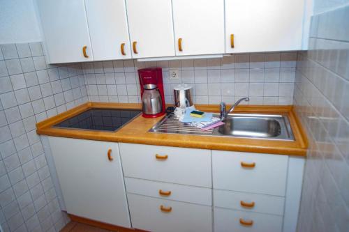 a kitchen counter with a sink and a mixer at Haus Ufen - In den Dünen 18c in Norderney