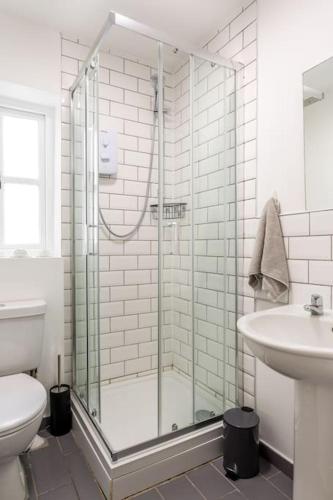 a bathroom with a shower and a toilet and a sink at Stylish 2Bed 2Bath Seafront Patio Apartment in Brighton & Hove