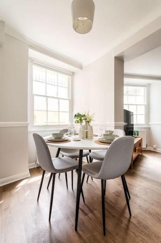 a dining room with a table and chairs at Stylish 2Bed 2Bath Seafront Patio Apartment in Brighton & Hove