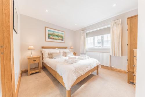 - une chambre avec un grand lit et une fenêtre dans l'établissement Silver Howe Cottage, Coniston, à Coniston