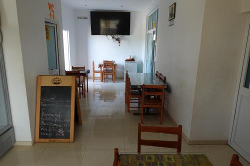 comedor con mesa, sillas y pizarra en Residencial Ribeira Torta, en Porto Novo