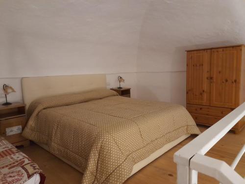 Monolocale nonna Elena في بروسيدا: غرفة نوم بسرير وخزانة خشبية
