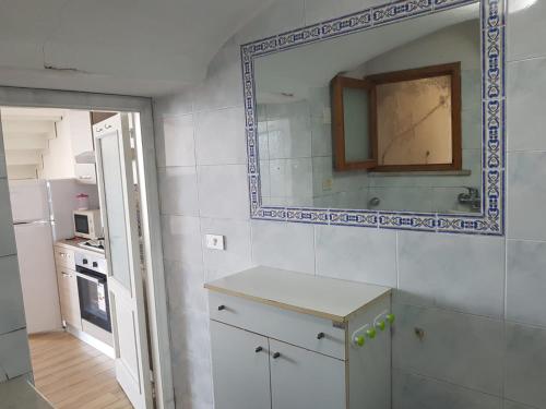 uma cozinha com um espelho na parede e um lavatório em Monolocale nonna Elena em Procida