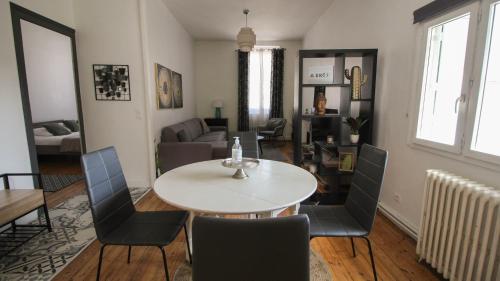 a dining room and living room with a table and chairs at Residence Pasteur Angouleme in Angoulême