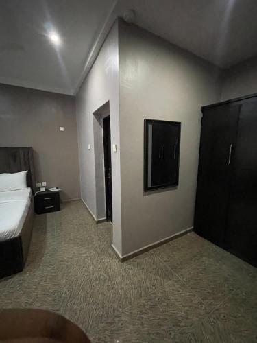アブジャにあるNexus Xpress Hotelのベッドとテレビ付きのホテルルーム