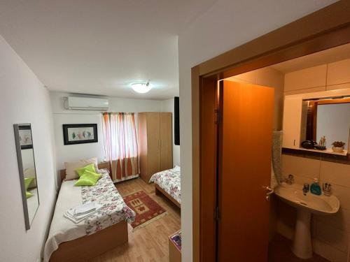 Habitación pequeña con cama y lavamanos en Aparmani Ušće, en Trstenik