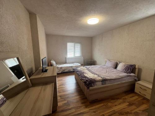 ein Schlafzimmer mit einem Bett und einem TV in der Unterkunft Къща за гости ДАП Баните in Banite
