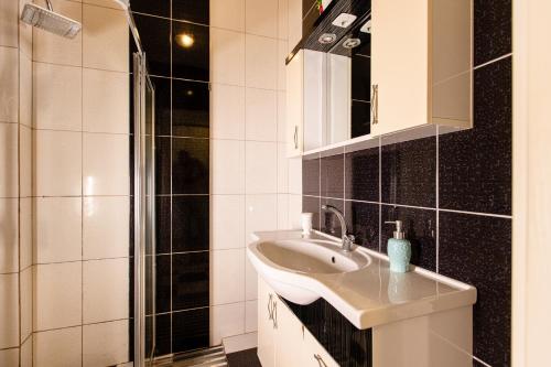 uma casa de banho com um lavatório e um chuveiro em Keyif Pension & Aparts em Cirali
