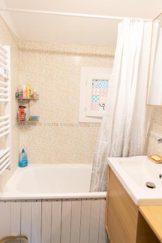 une salle de bain blanche avec une baignoire et un lavabo dans l'établissement Maison au calme, à Villeneuve-Loubet