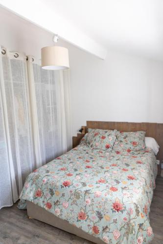 une chambre avec un lit avec une couette fleurie dans l'établissement Maison au calme, à Villeneuve-Loubet
