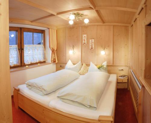 a bedroom with a large bed with white pillows at Aparthotel Gallahaus in Zell am Ziller