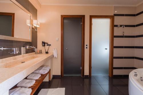 a bathroom with a sink and a toilet and a tub at Restia in Almiros Beach