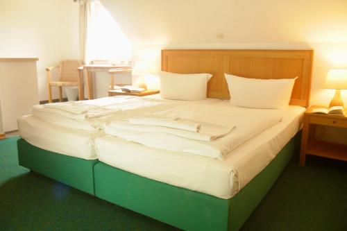 a bedroom with a large bed with white sheets at Hotel Enddorn Appartement in Grieben