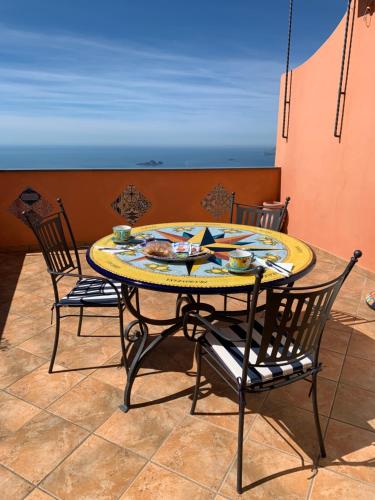 una mesa y sillas en un patio con vistas al océano en Anna Apartment en Positano