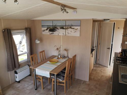 een keuken en eetkamer met een tafel en stoelen bij RBR 135 - Beach Resort Kamperland in Kamperland