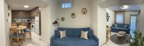 sala de estar con sofá azul y cocina en Marble House en Kavala