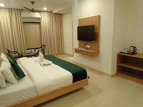 a bedroom with a bed and a flat screen tv at Sun Stone Hotel & Club - Jawai in Sheoganj