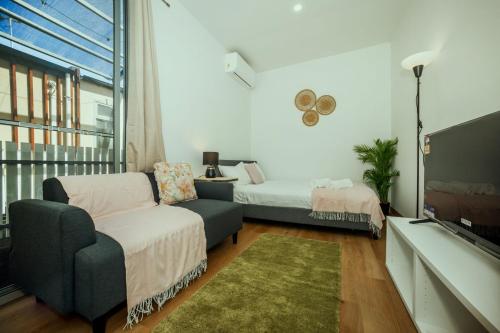 uma sala de estar com uma cama, um sofá e uma televisão em Stellar Residence #2 em Adelaide