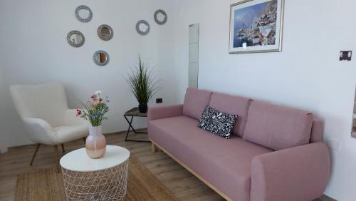 sala de estar con sofá rosa y mesa en Rooms and Apartment Matosevic, en Rovinj