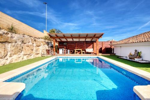 einen Pool vor einem Haus mit einer Steinmauer in der Unterkunft beautiful villa private pool & Jacuzzi with panoramic views in Mutxamel