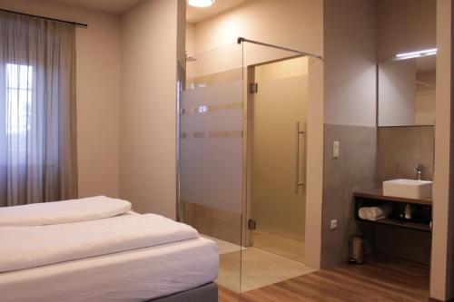 a bathroom with a shower and a bed and a sink at Trautes Quartier in Bad Gleichenberg