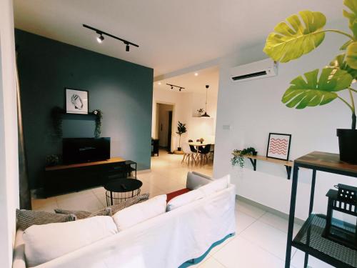 ein Wohnzimmer mit einem weißen Sofa und einer grünen Wand in der Unterkunft Arte Plus by Stay Relax in Kuala Lumpur
