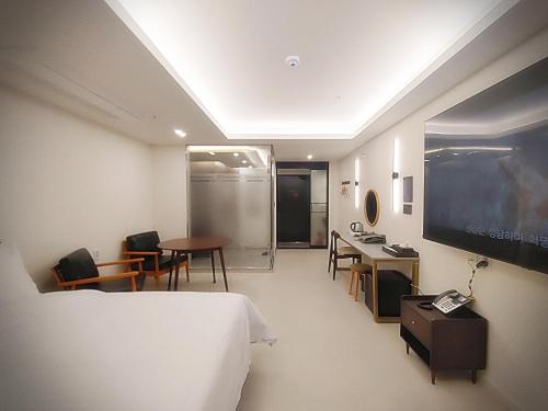 a hotel room with a bed and a flat screen tv at Bluebird Hotel in Incheon
