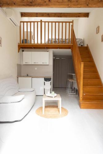 un salon avec un canapé et un escalier dans l'établissement Maisonnette au calme, à Villeneuve-Loubet