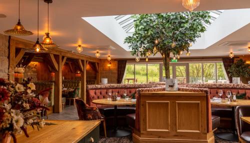 een restaurant met tafels, stoelen en ramen bij Peak Edge Hotel in Chesterfield