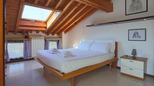 a bedroom with a large white bed with a skylight at Italianway - Panoramic Dream House in San Fedele Intelvi