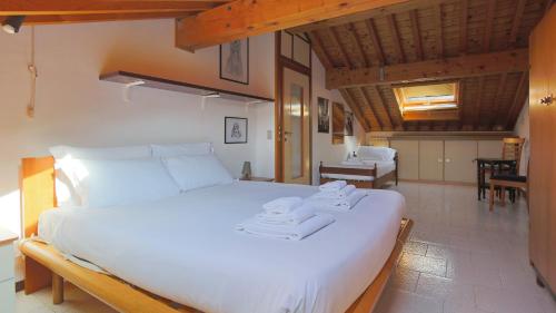 1 dormitorio con 1 cama blanca grande y toallas. en Italianway - Panoramic Dream House en San Fedele Intelvi