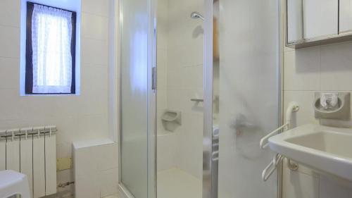 a white bathroom with a shower and a sink at Italianway - Panoramic Dream House in San Fedele Intelvi
