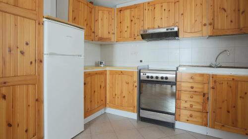a kitchen with wooden cabinets and a stove top oven at Italianway - Panoramic Dream House in San Fedele Intelvi
